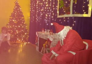 Mikołaj szuka w worku prezentów dla dzieci
